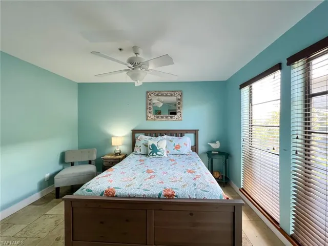 Tiled bedroom featuring ceiling fan