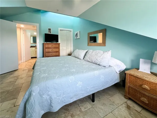 Tiled bedroom featuring a closet and ensuite bath