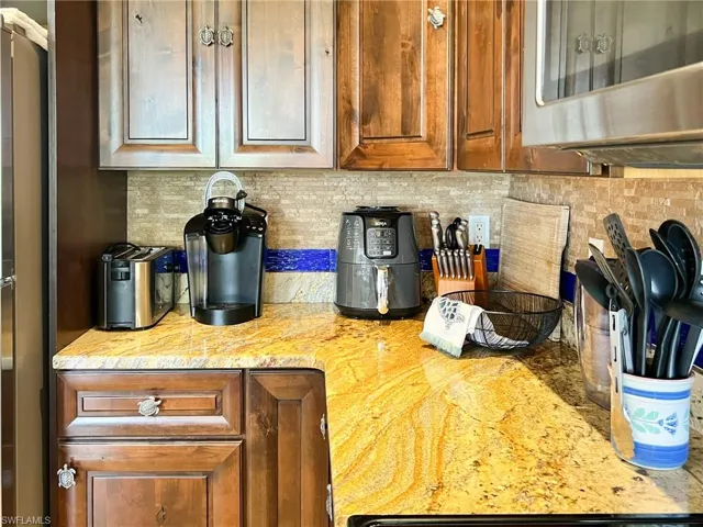 Kitchen featuring light stone counters and tasteful backsplash