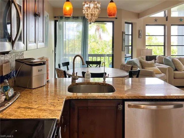 Kitchen with pendant lighting, sink, stainless steel appliances, and a notable chandelier