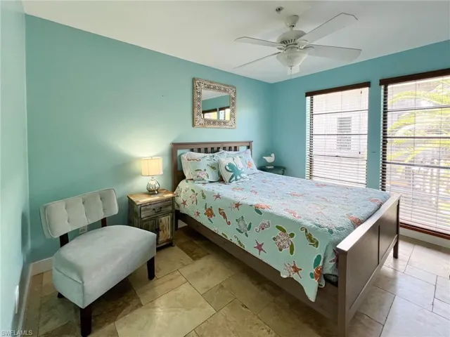 Bedroom with ceiling fan and light tile patterned flooring