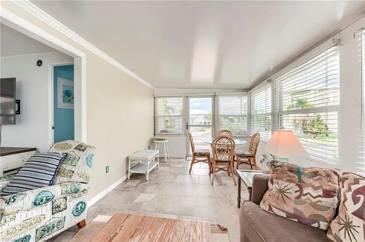 Sunroom featuring baseboards and ornamental molding