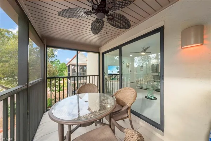 Sunroom / solarium with a balcony and a ceiling fan