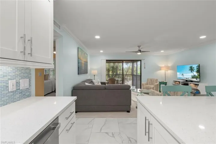 Kitchen with white cabinetry, light stone counters, light marble finish floors, recessed lighting, and open floor plan