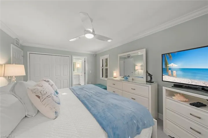 Bedroom featuring crown molding, a closet, a ceiling fan, and light carpet
