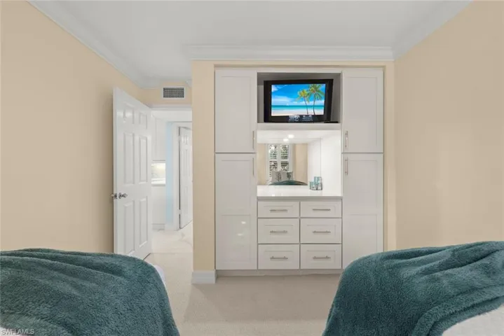 Bedroom with crown molding and light carpet