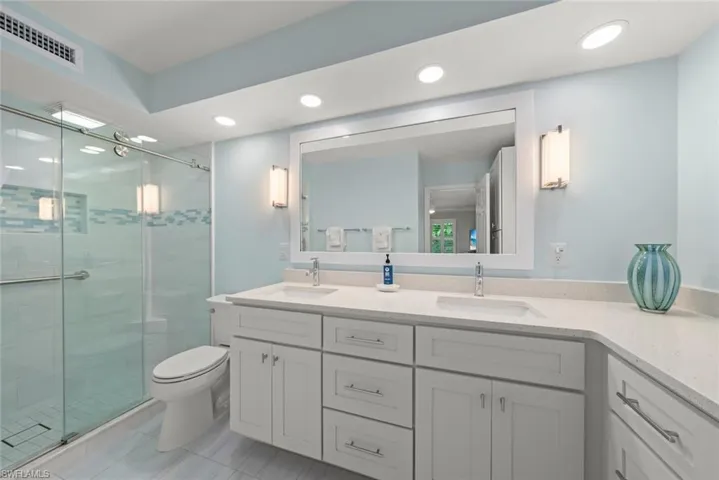 Full bath featuring double vanity, a stall shower, and recessed lighting