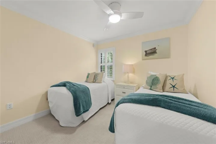Carpeted bedroom with crown molding and a ceiling fan