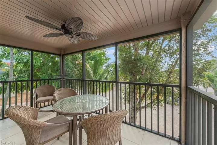 Sunroom featuring ceiling fan, a balcony, and healthy amount of natural light