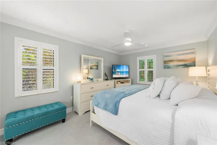 Bedroom with crown molding, ceiling fan, and carpet flooring