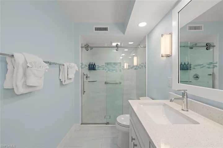 Full bath featuring vanity, a shower stall, recessed lighting, and light tile patterned flooring