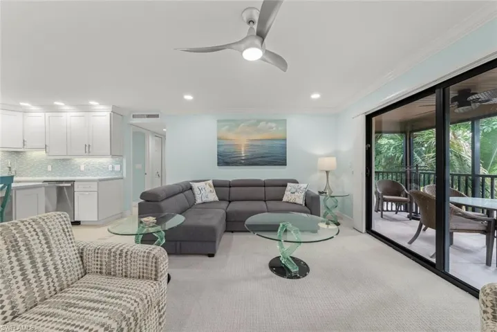 Living room with ornamental molding, ceiling fan, recessed lighting, and light carpet