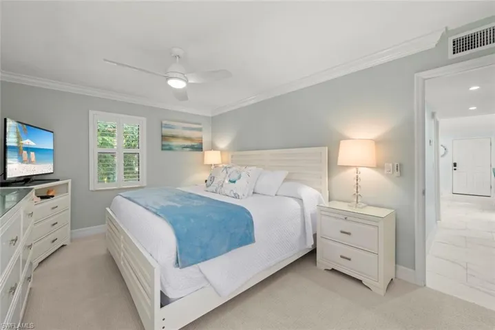Bedroom with crown molding, a ceiling fan, and light carpet