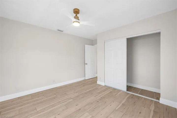 Unfurnished bedroom featuring baseboards, visible vents, a closet, and light wood finished floors