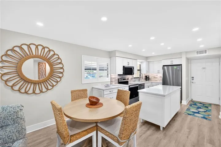 Dining space with light wood-style floors and recessed lighting