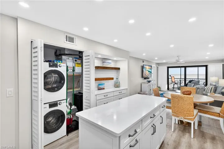 Washroom with estacked washer and dryer, recessed lighting, light wood-style flooring, and a ceiling fan