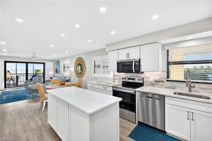 Kitchen with white cabinetry, open floor plan, stainless steel appliances, a kitchen island, and recessed lighting