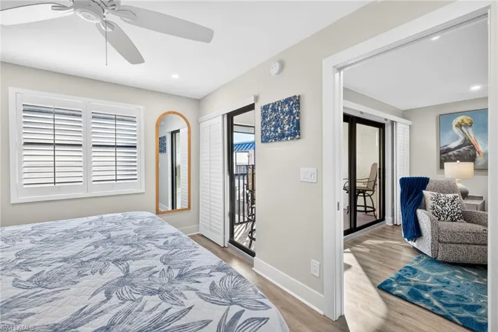 Bedroom featuring access to exterior, light wood-style flooring, and a ceiling fan