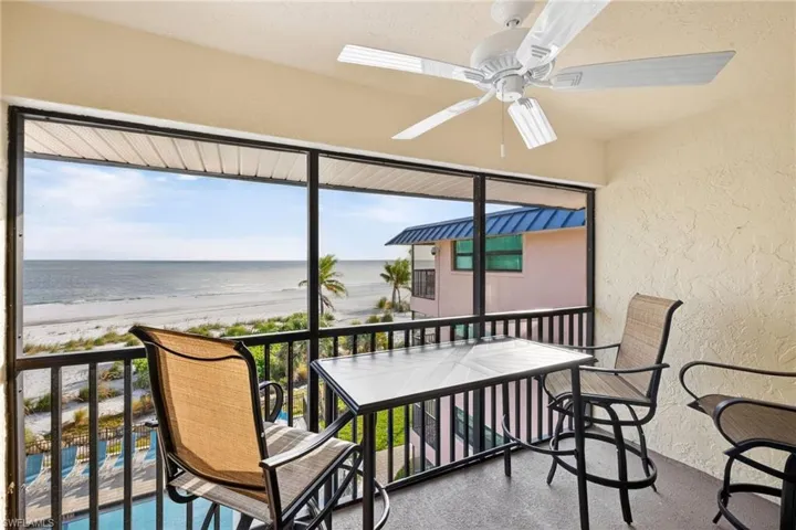 Sunroom with view of water and beach