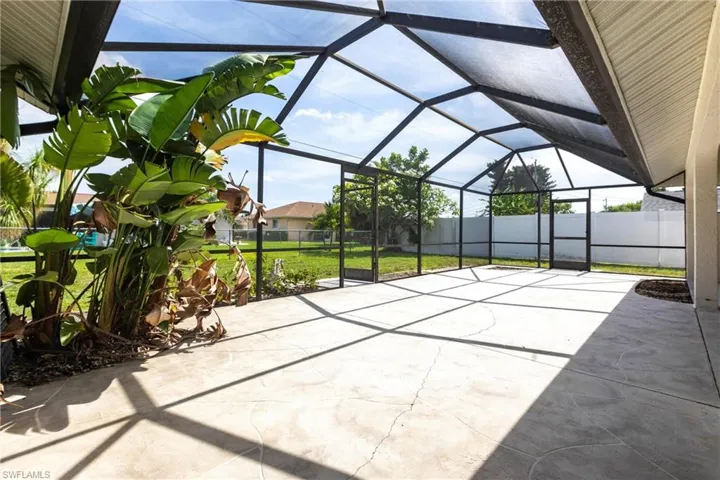 Fenced backyard featuring a patio area and glass enclosure