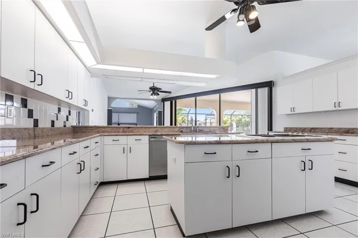 Kitchen with a ceiling fan, dishwasher, white cabinetry, white gas stovetop, and light stone countertops