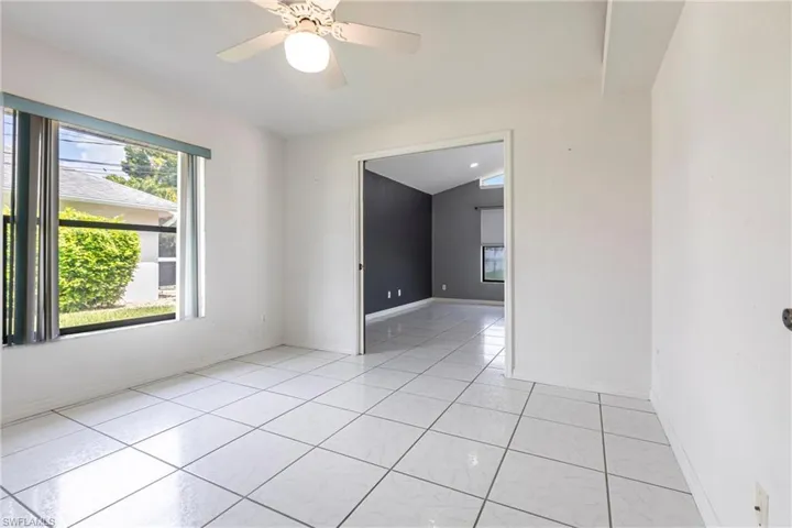 Empty room featuring light tile patterned flooring and ceiling fan