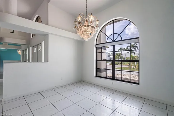 Empty room featuring a chandelier and light tile patterned flooring