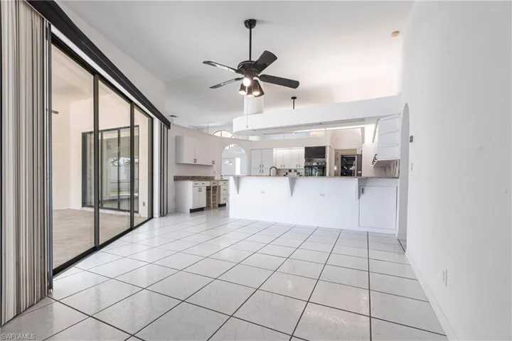 Unfurnished living room with a ceiling fan and light tile patterned floors