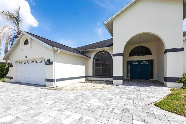View of front of property featuring stucco siding, an attached garage, driveway, and roof with shingles