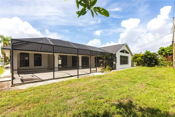 Back of house featuring a patio, a lawn, and a lanai