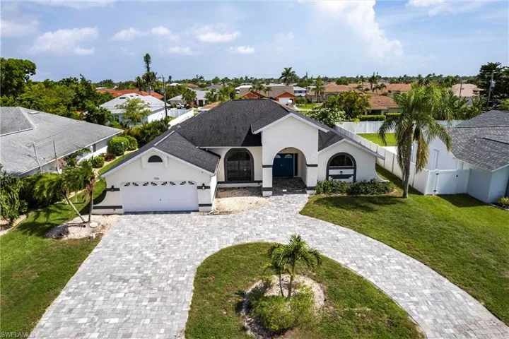 View of front of home featuring decorative driveway, stucco siding, a garage, a residential view, and roof with shingles