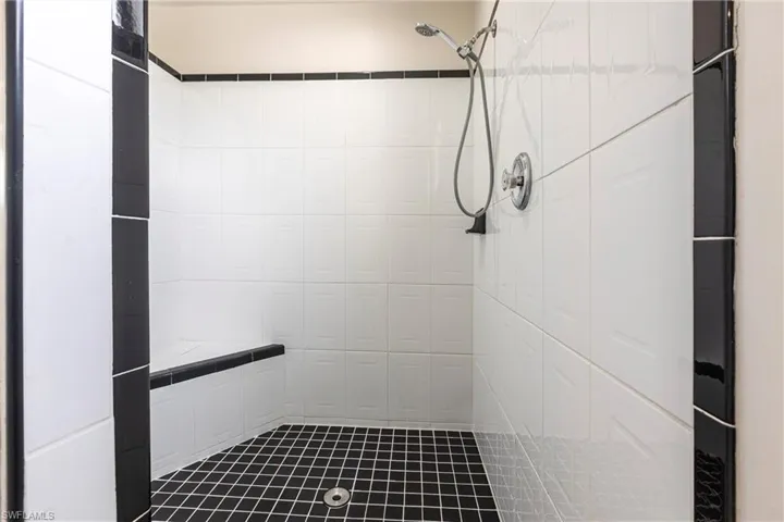 Bathroom featuring a tile shower and tile walls