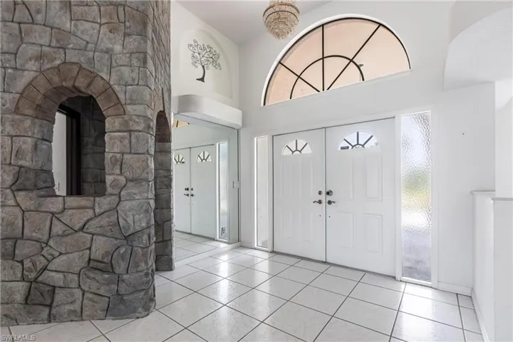 Foyer entrance featuring tile patterned floors and a towering ceiling