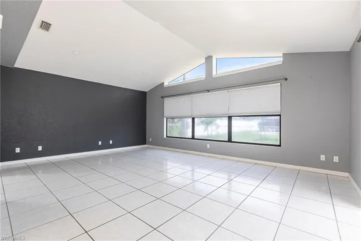 Spare room with lofted ceiling and light tile patterned floors