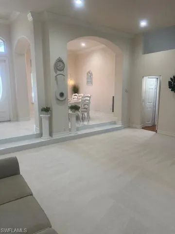 Carpeted living room with ornamental molding
