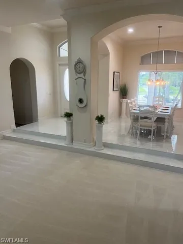 Foyer entrance with ornamental molding and an inviting chandelier