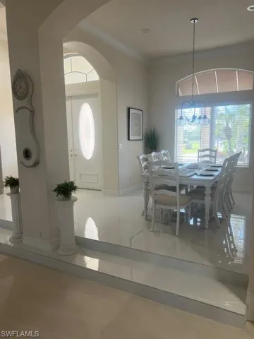 Entrance foyer with a healthy amount of sunlight, crown molding, and an inviting chandelier
