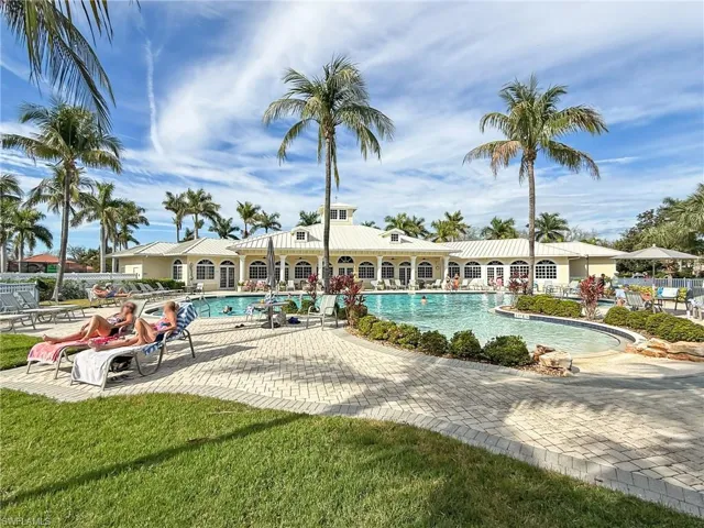 Community pool with a patio area and fence