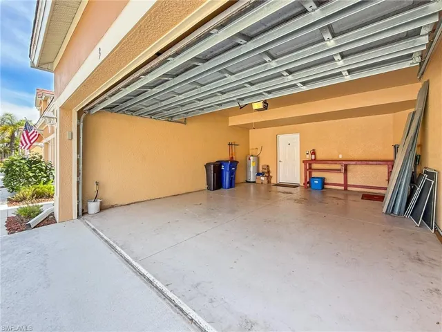 Garage featuring a carport, electric water heater, and a garage door opener