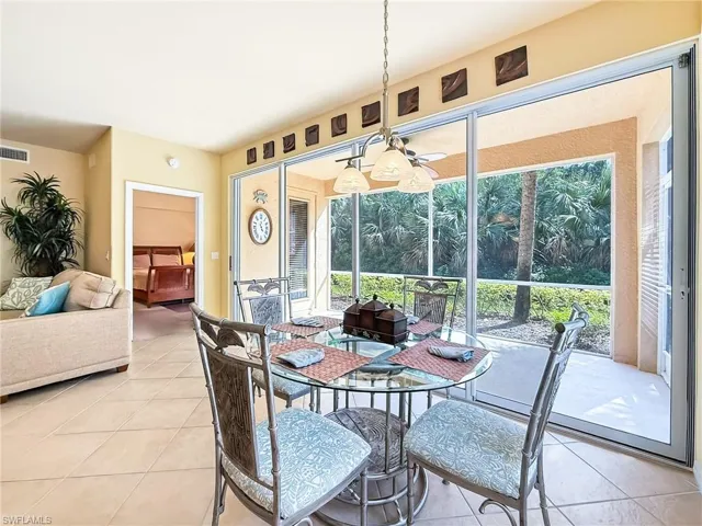 Dining room with light tile patterned floors, a sunroom, and a ceiling fan