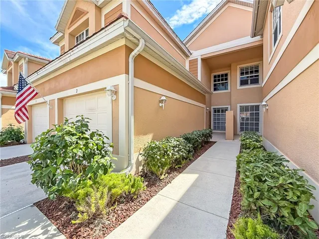 View of exterior entry with a garage and stucco siding