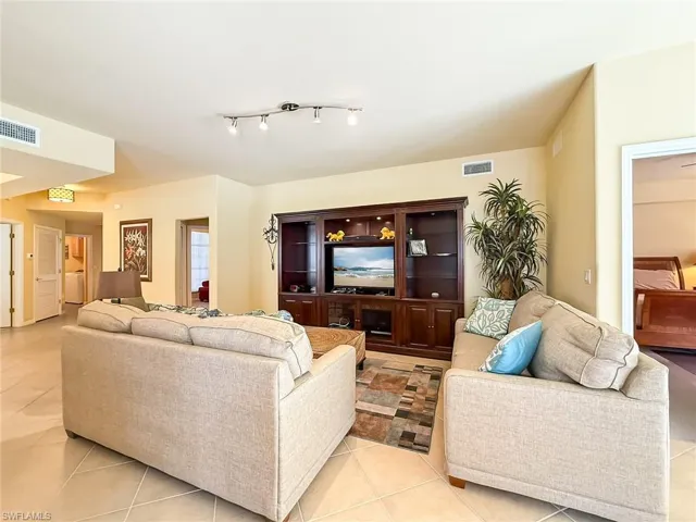 Living room with light tile patterned floors and visible vents