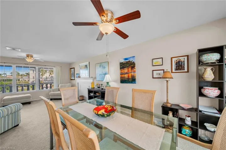 Carpeted dining space featuring a ceiling fan