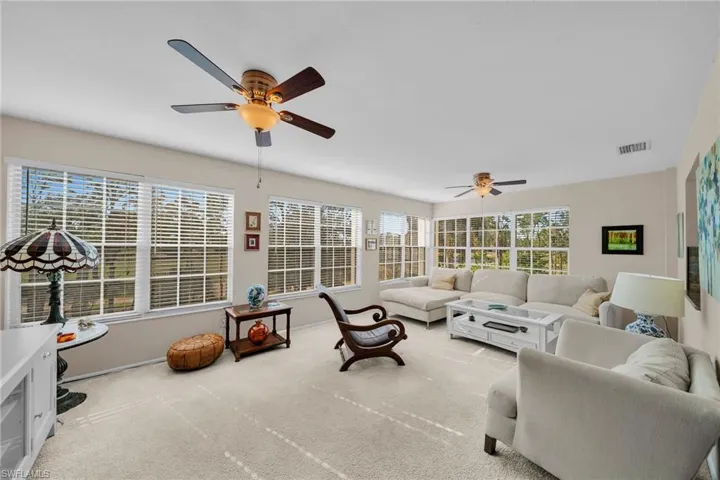Living area featuring ceiling fan and light colored carpet