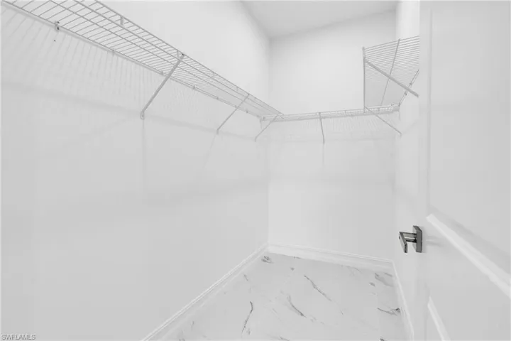 Walk in closet featuring marble look tile flooring