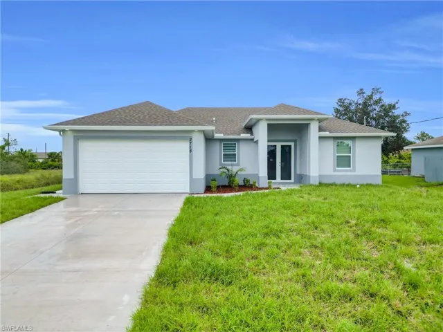 View of front facade with french doors, stucco siding, a garage, and a front yard