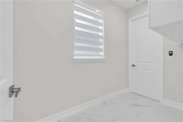 Washroom featuring baseboards and light marble finish floors
