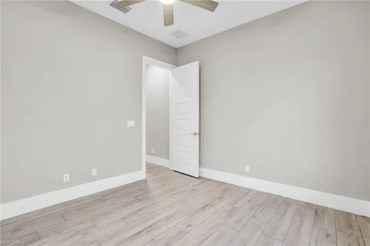 Spare room with ceiling fan and light wood-type flooring