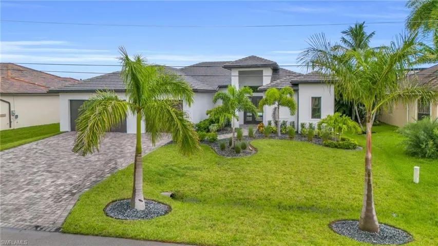View of front facade featuring a front yard and a garage