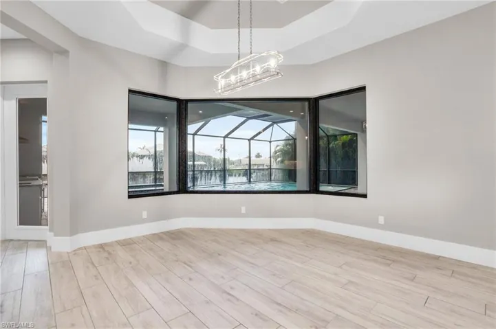 Unfurnished room featuring an inviting chandelier and light hardwood / wood-style flooring